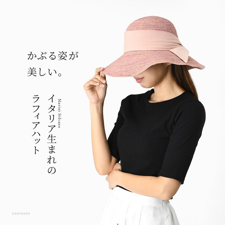 イタリア製ラフィア帽子をかぶった女性モデル。つば広×ビッグリボンが上品な印象。UVカット・折りたたみ可能なレディース夏帽子。