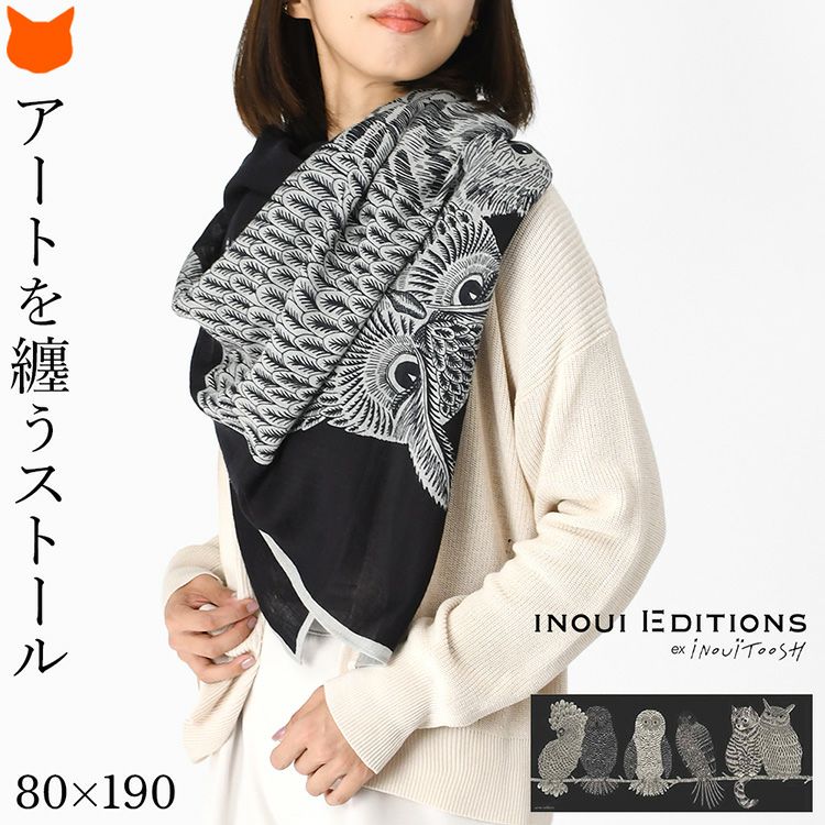 INOUI EDITIONS イヌイエディションズ 大判ウールストールを巻いた女性。黒地にフクロウ、オウム、猫が描かれたおしゃれなデザイン。軽くて暖かい秋冬向けレディースストール