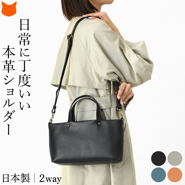 日本製本革ショルダーバッグを肩掛けする女性。横型3層でマチ広、ペットボトル収納可能な2wayミニハンドバッグ